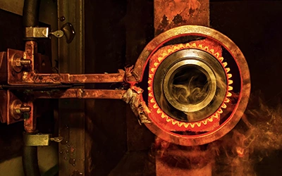 closeup-calcining-hot-metal-steel-gear-parts-in-a-factory-induction-furnace-with-smoke-and-flame-ss-1945495897.webp